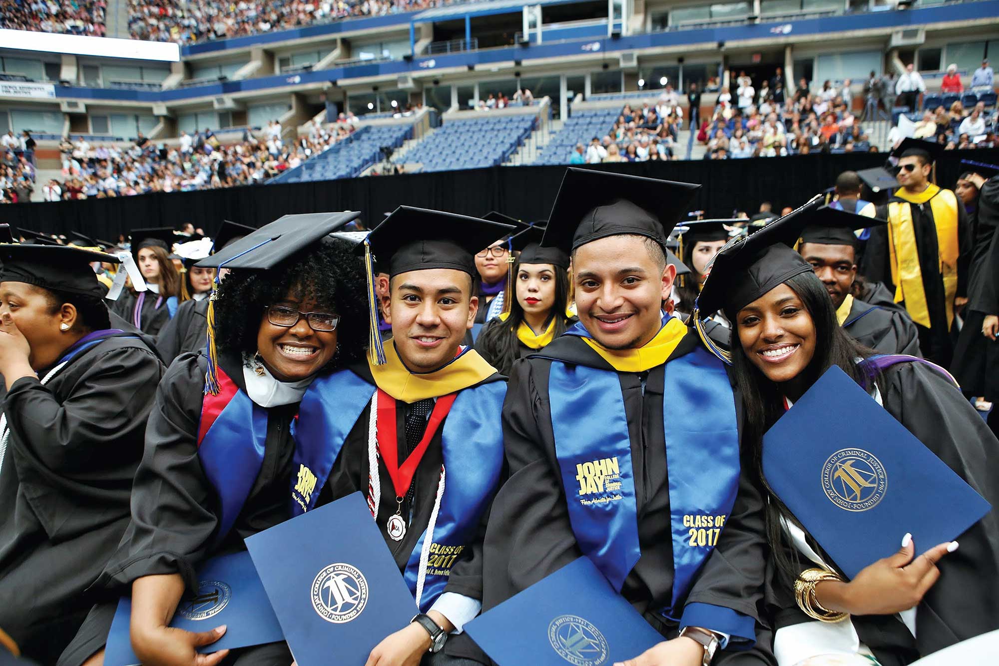 Four students smiling at commencement 