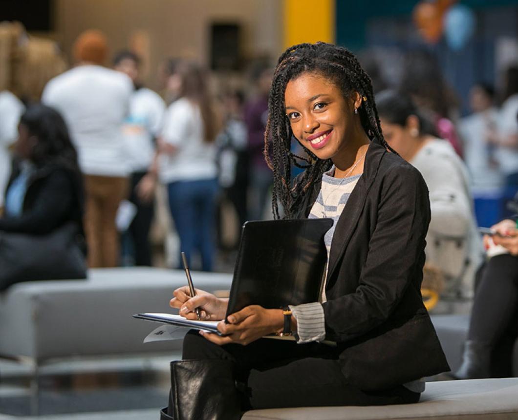 Student with notepad in the Atrium