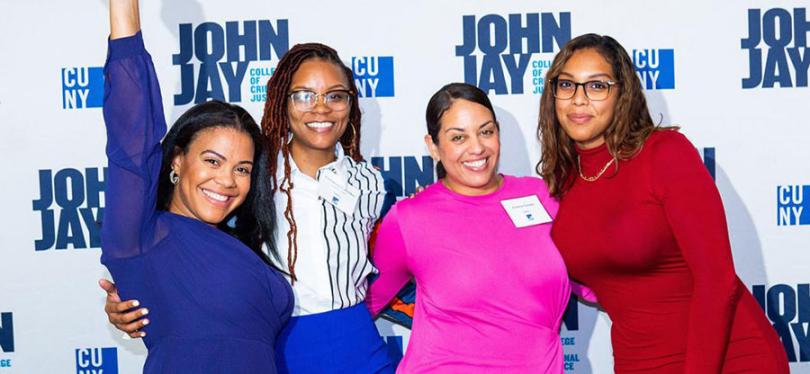 Four women posing at John Jay College event